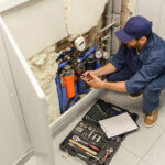 handyman-in-uniform-repairing-water-supply-system-9KGRWZ5.jpg